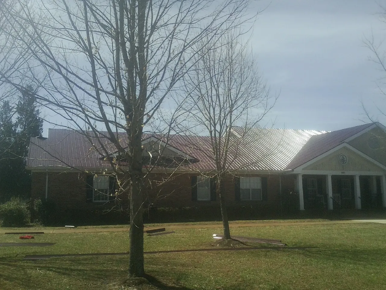 Red metal roof on a brick building seen from the front lawn in Fort Lauderdale