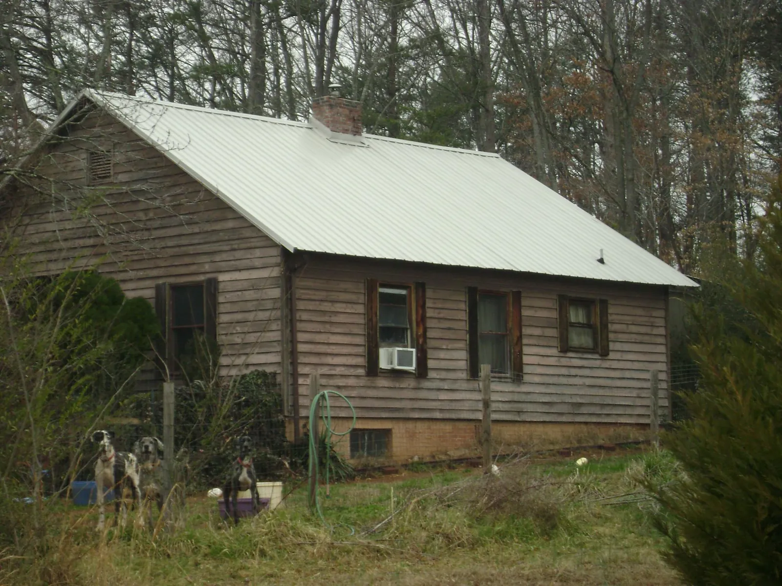 White metal roof on an old wood sided farmhouse, from a Asphalt Shingle Roof Repair job in Fort Lauderdale